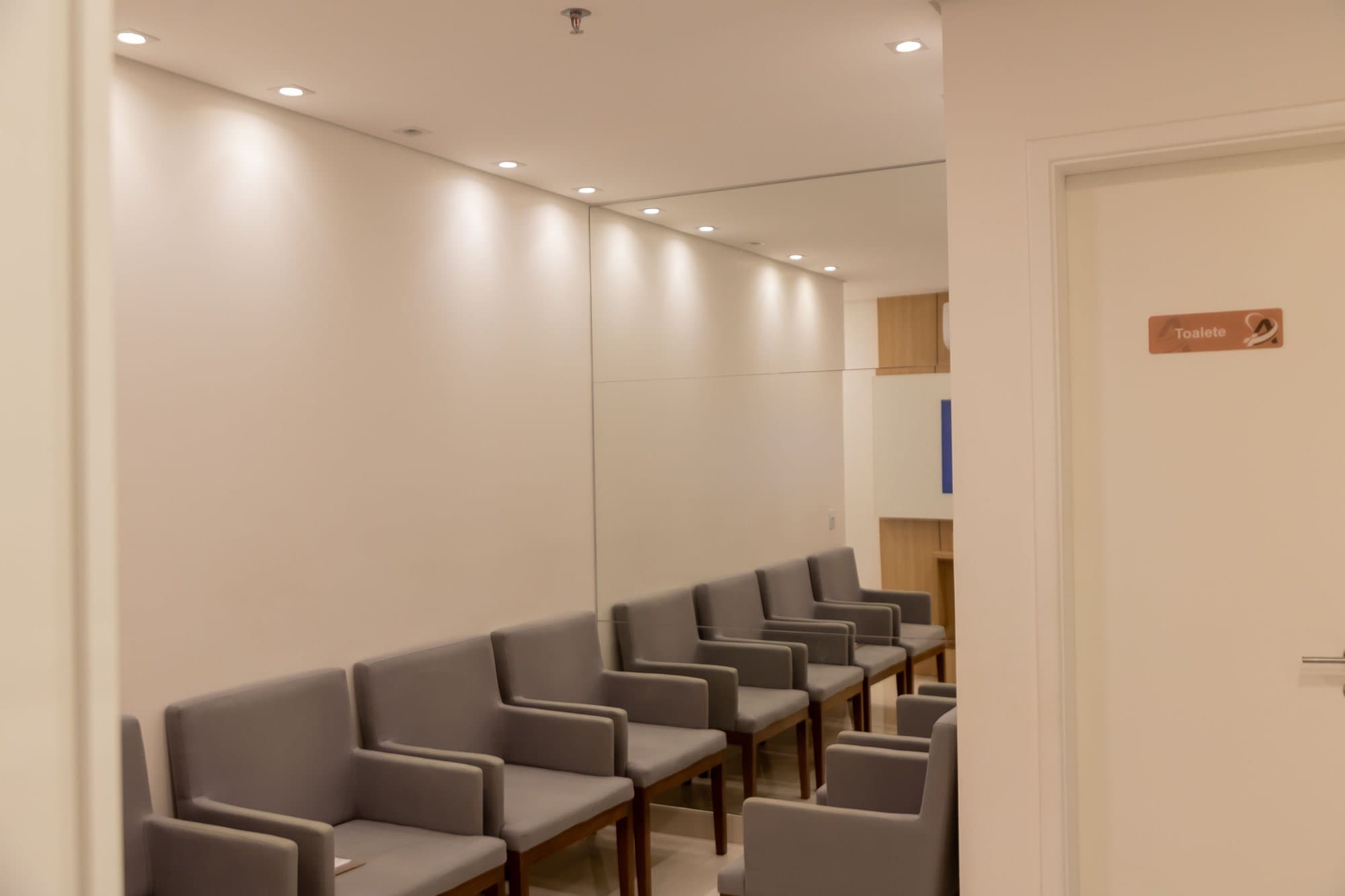 Sala de espera da clínica com poltronas e iluminação clara