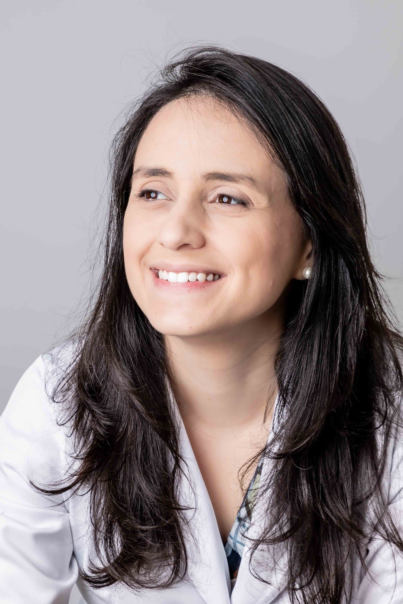 Dra. Paula Azevedo sorrindo, de jaleco branco